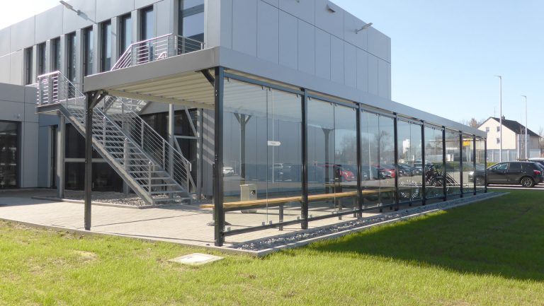 Rückwände der Überdachung PROTECT mit Glasscheiben bieten große Transparenz