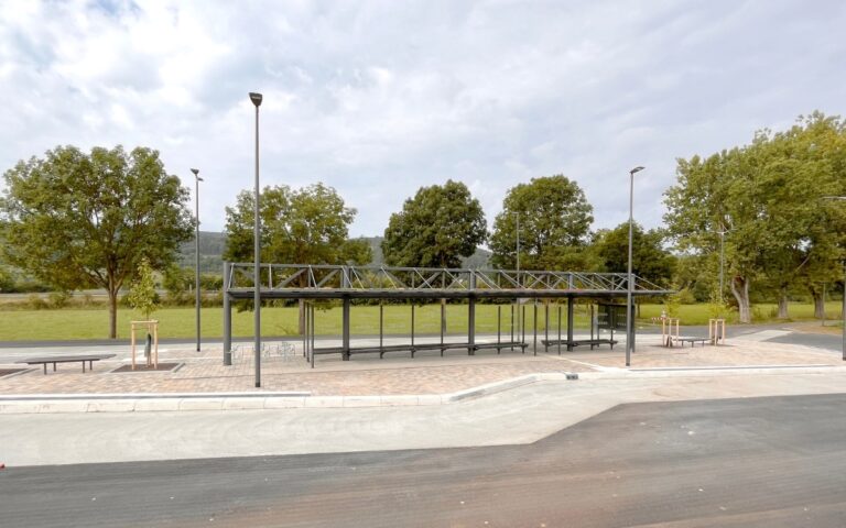 ZOB Hammelburg mit doppelzeiliger Überdachung System O mit Gründach, Sitzbänken, Windschutz- und Seitenwänden, Infovitrine und Fahrradbügeln
