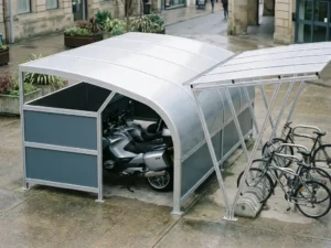 Aluminium-Motorradunterstand und Fahrradüberdachung aus Stahl in urbanem Raum, Touringmotorrad und Fahrräder darunter geparkt.