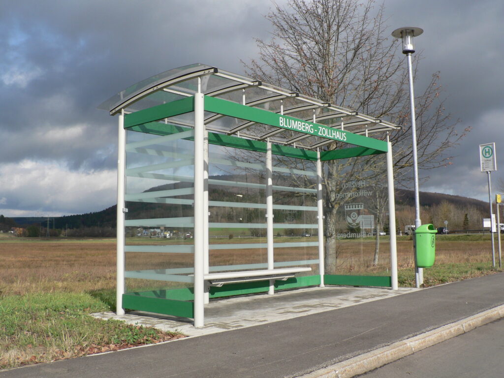 Wartehalle System BASIC mit Bogendach Blumberg mit grünem Funktionsband und Haltestellennamen
